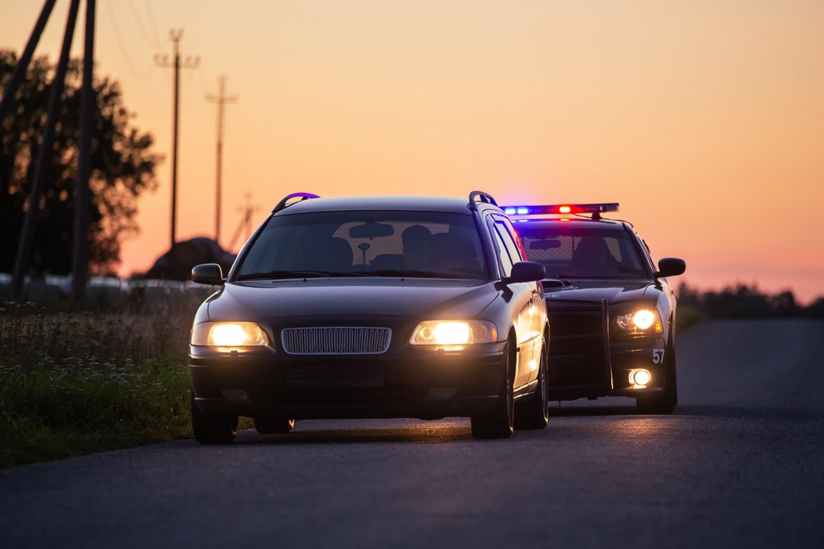 Rhode Island DUI consequences | Police car pulling over car on road | Experienced DUI Attorney | Stefanie A. Murphy
